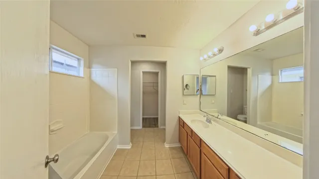 a spacious bathroom with a granite countertop sink a mirror and a shower
