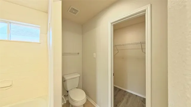 a bathroom with a toilet and a shower