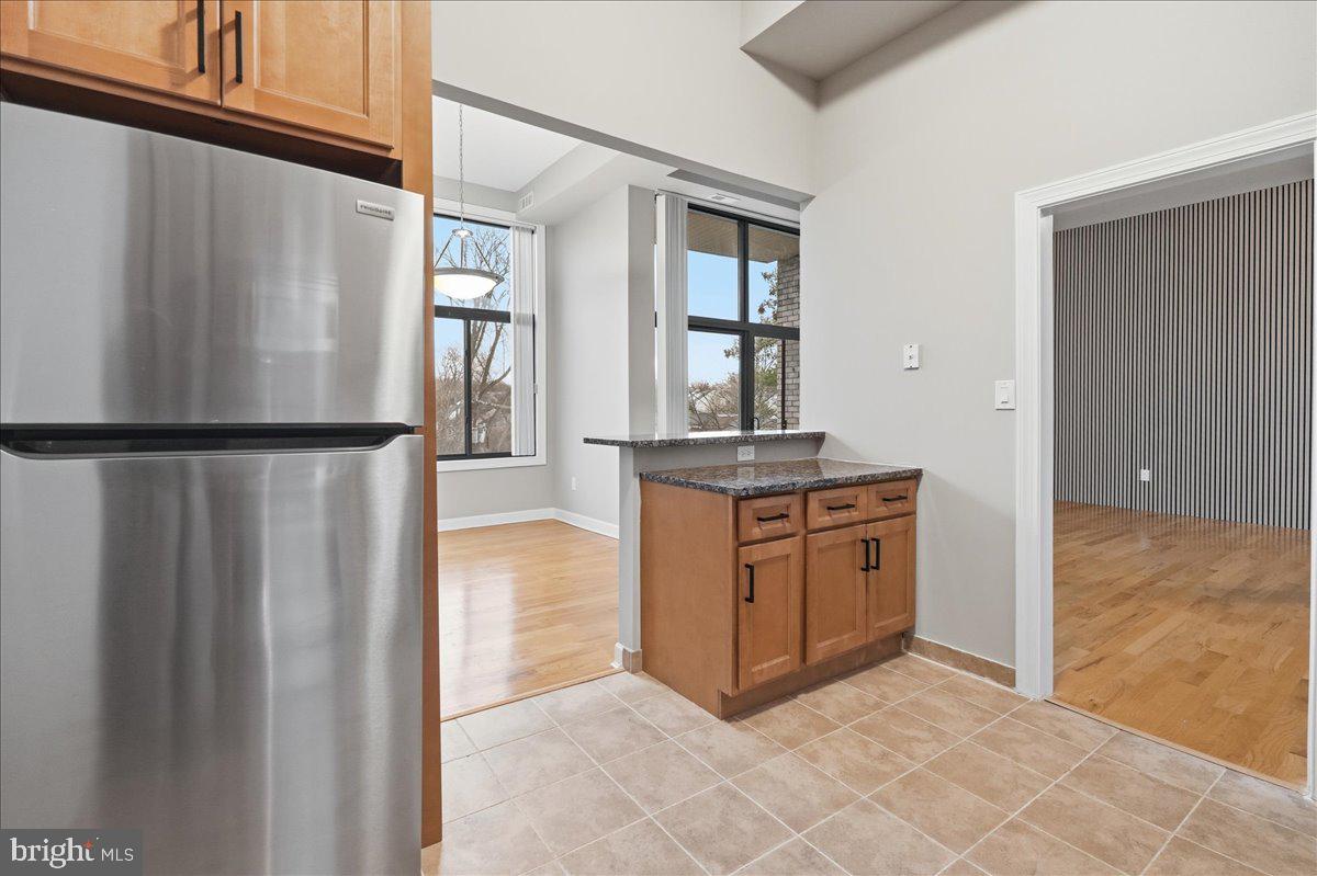 10860-10864 Bucknell Drive, Unit 301 Silver Spring, MD 20902 - Photo 9 of 24 a kitchen with stainless steel appliances granite countertop a refrigerator and a stove