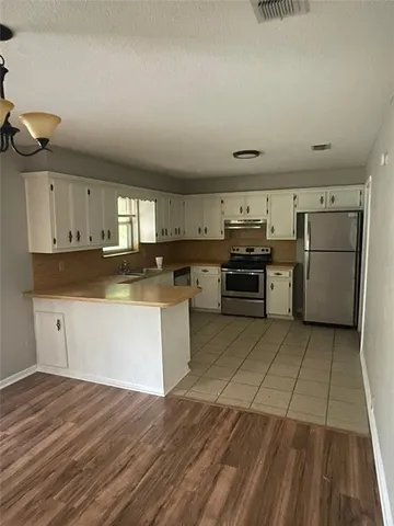 a large kitchen with stainless steel appliances granite countertop a stove and a refrigerator