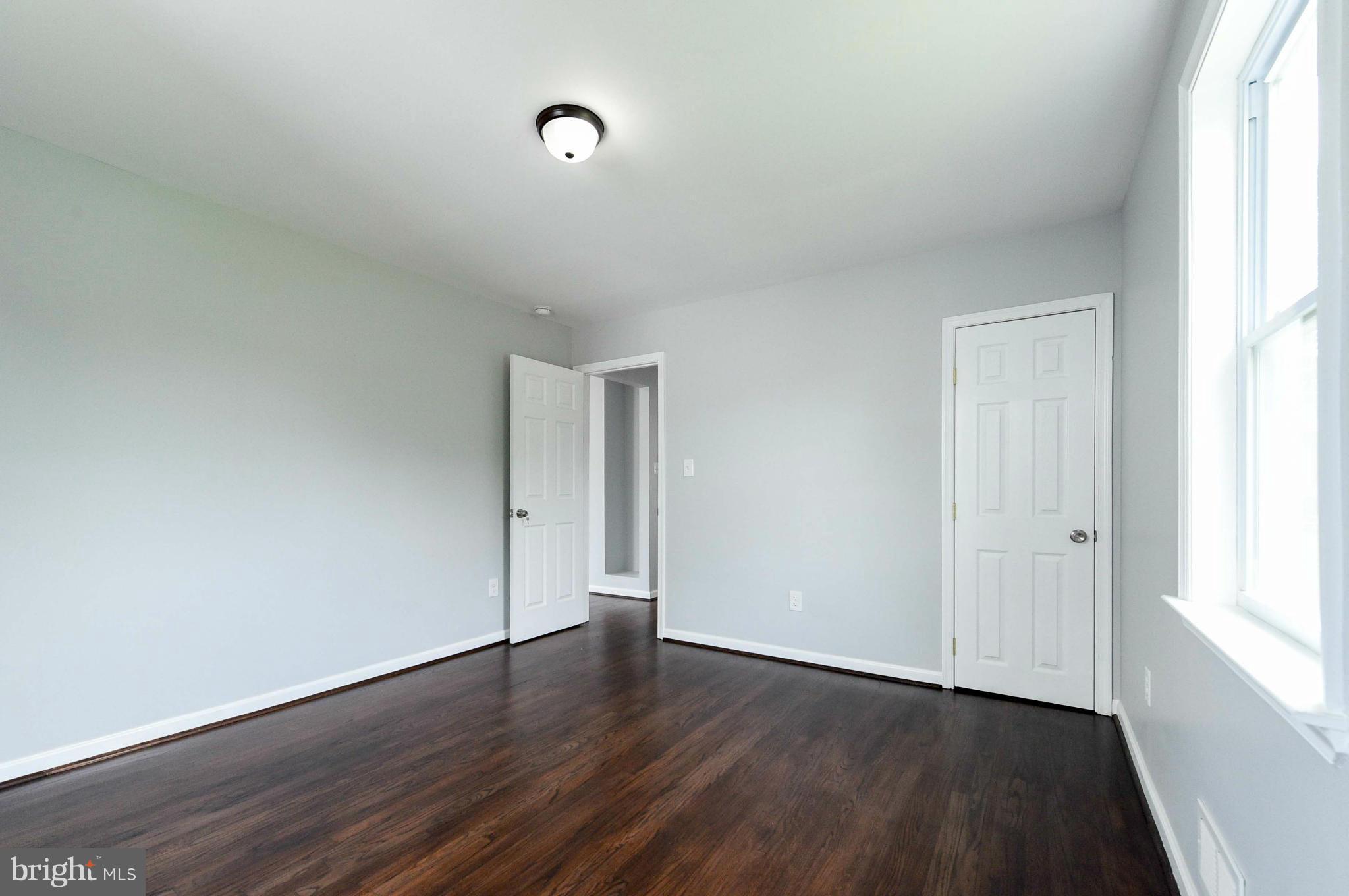 3822 Byfield Road Baltimore, MD 21207 - Photo 11 of 30 an empty room with wooden floor and windows