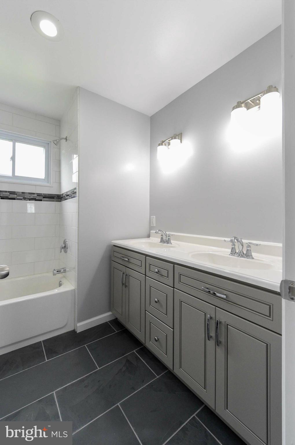 3822 Byfield Road Baltimore, MD 21207 - Photo 12 of 30 a bathroom with a granite countertop sink mirror and bathtub