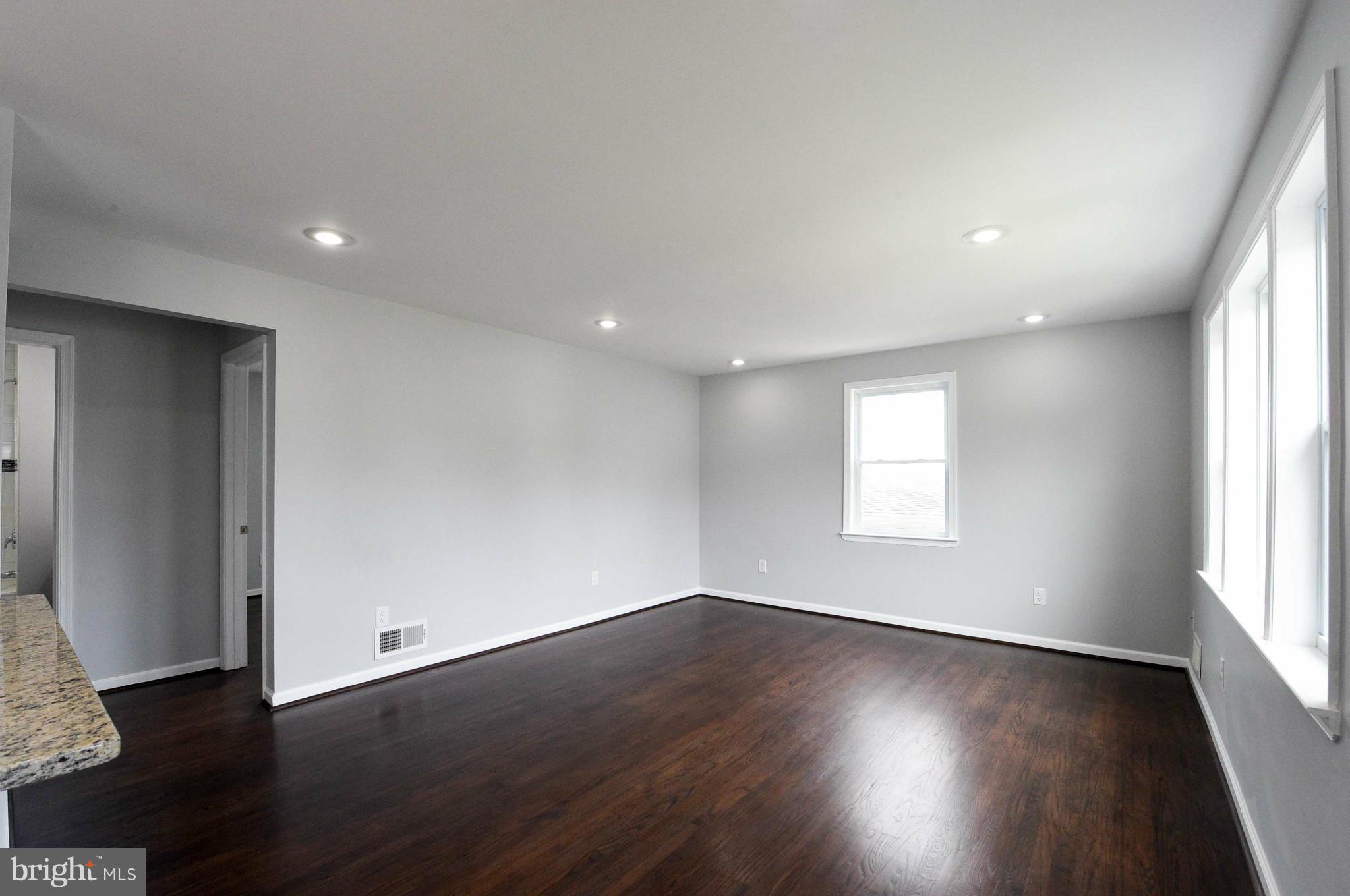 3822 Byfield Road Baltimore, MD 21207 - Photo 7 of 30 an empty room with wooden floor and windows