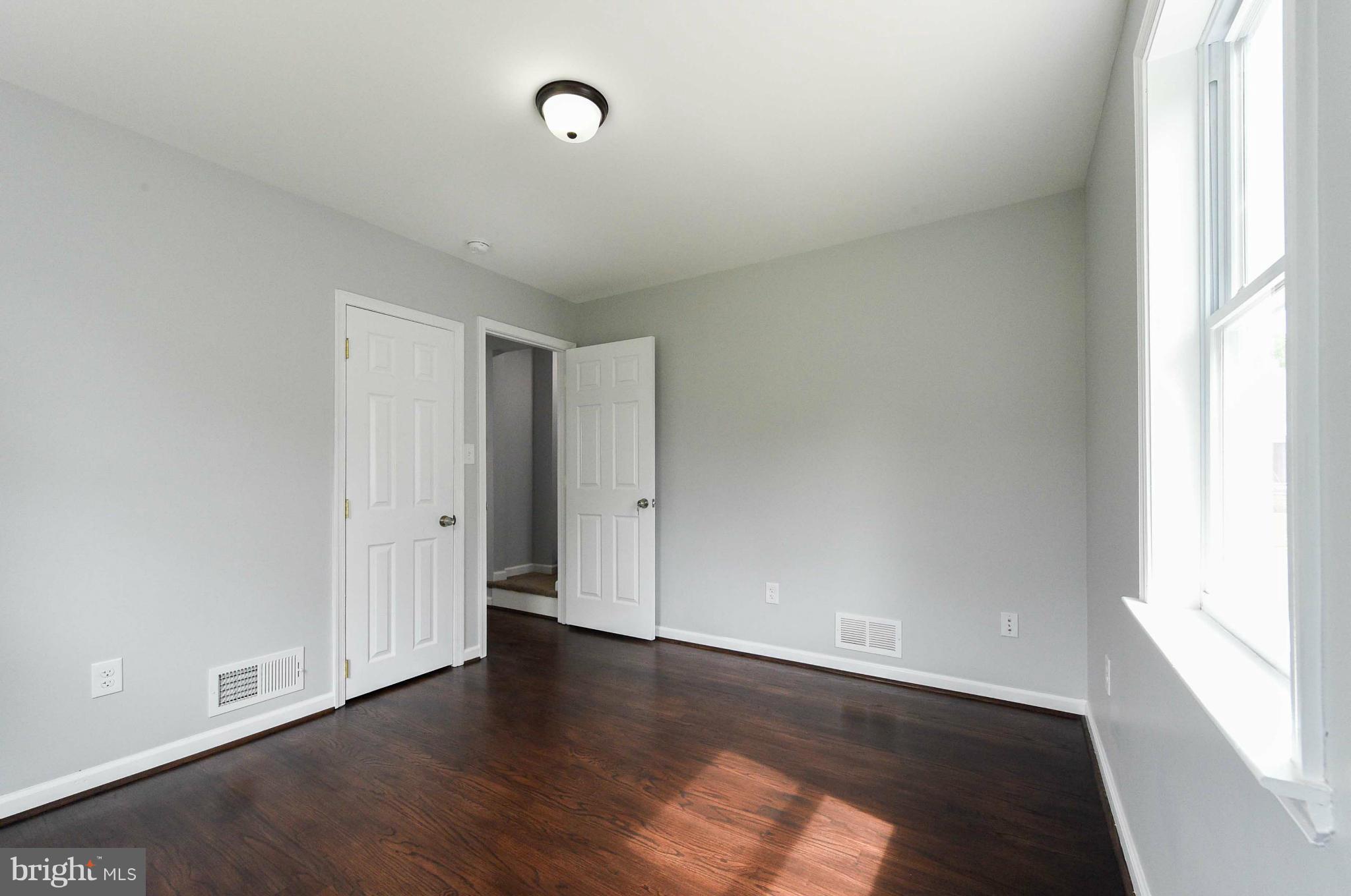 3822 Byfield Road Baltimore, MD 21207 - Photo 10 of 30 a view of an empty room with wooden floor and a window
