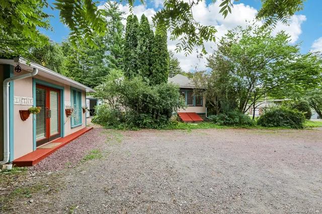 a view of a house with a patio and a yard