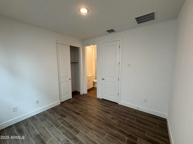 a view of a hallway with wooden floor and closet area