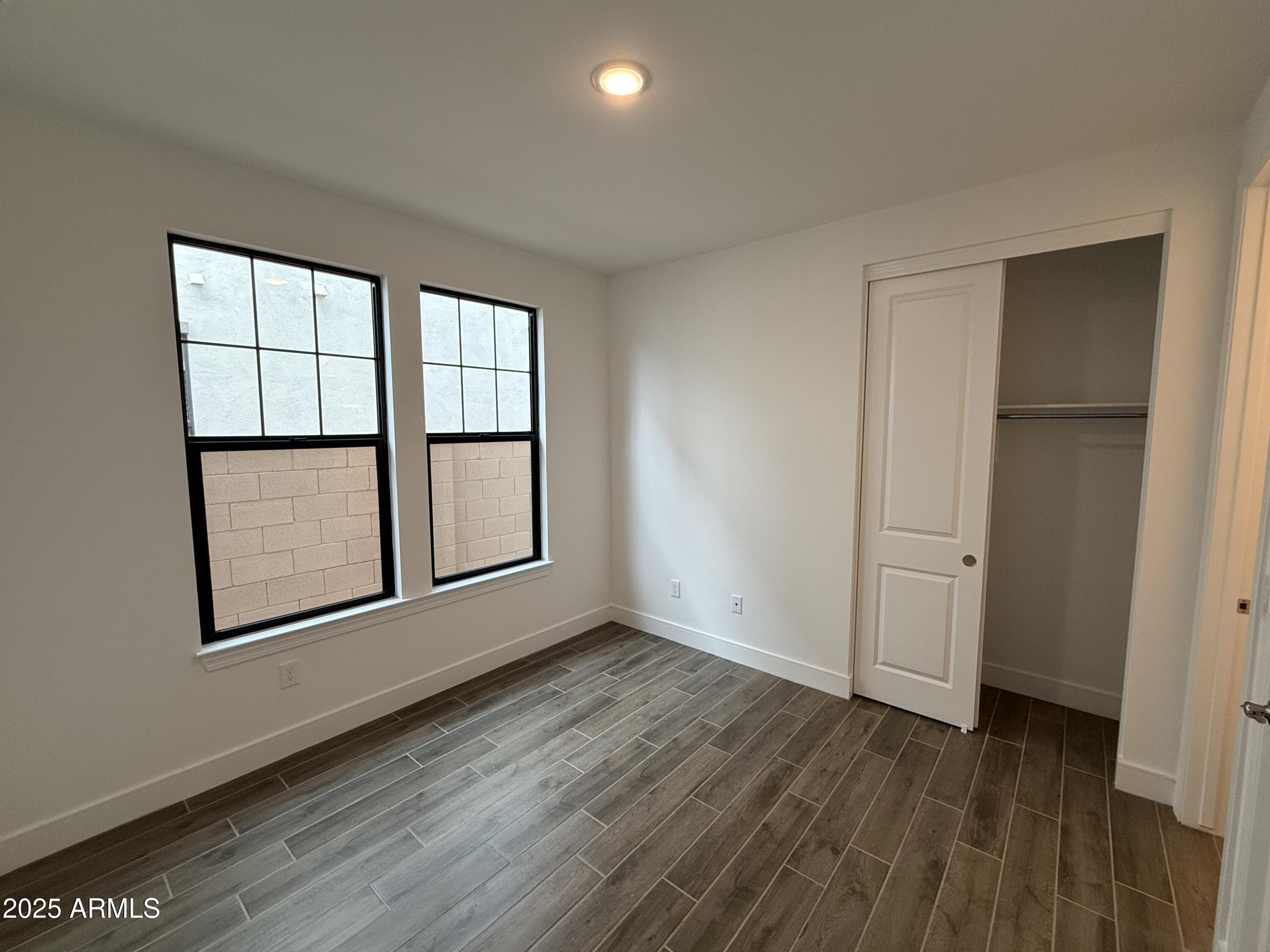 2390 West Los Arboles Place Chandler, AZ 85224 - Photo 15 of 41 an empty room with wooden floor and windows