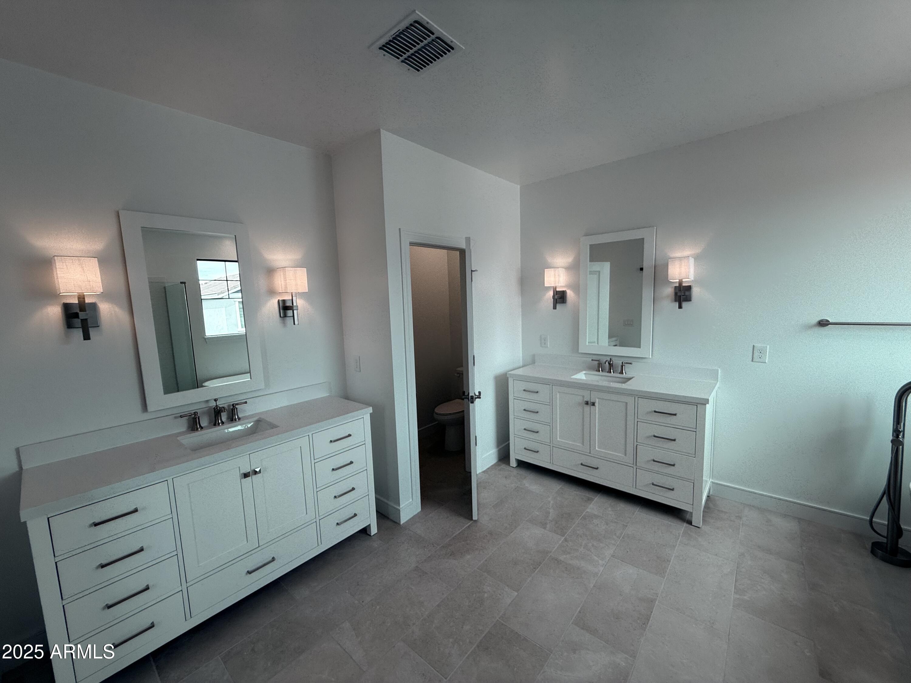 2390 West Los Arboles Place Chandler, AZ 85224 - Photo 25 of 41 a bathroom with a double vanity sink a toilet a mirror and window