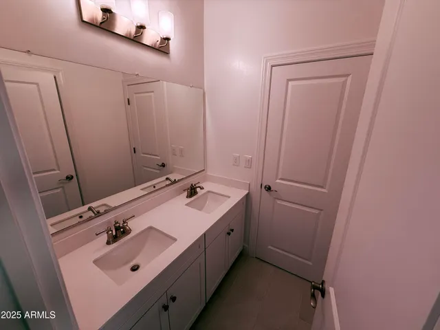 a bathroom with a double vanity sink and mirror
