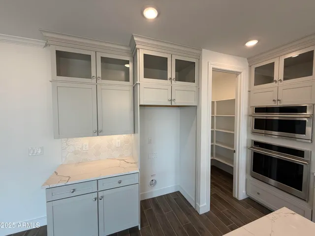 a view of a kitchen island a sink stainless steel appliances and cabinets