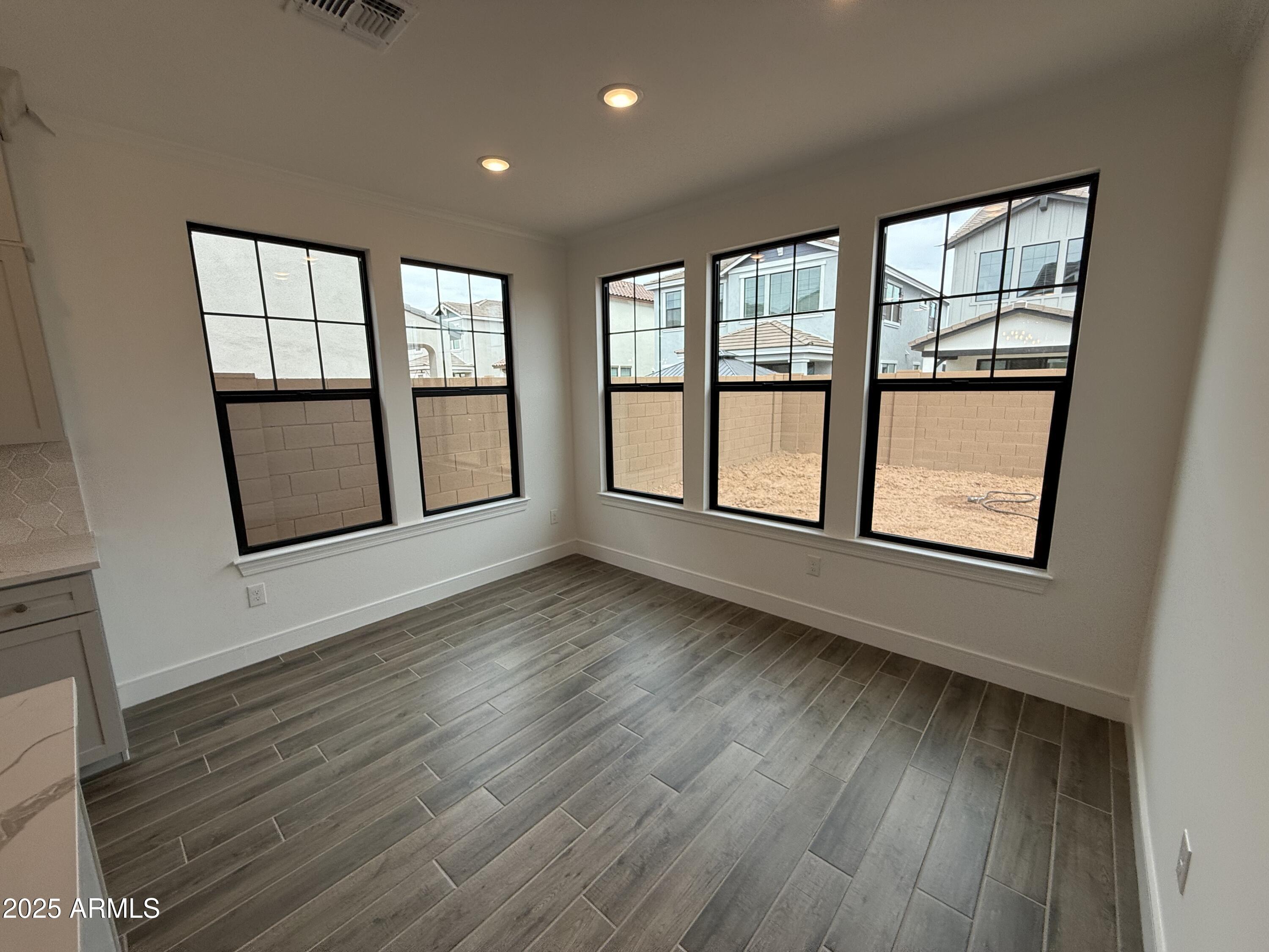 2390 West Los Arboles Place Chandler, AZ 85224 - Photo 8 of 41 a view of an empty room with wooden floor and a window