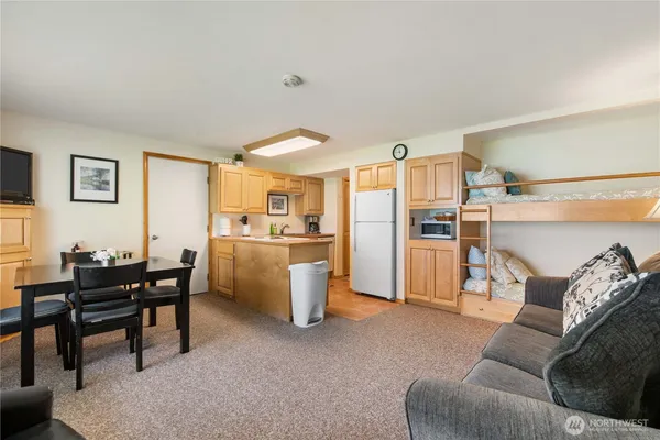 a living room with furniture a refrigerator and kitchen view