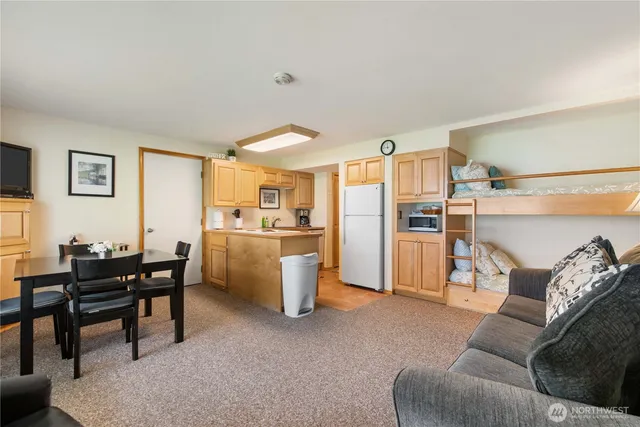 a living room with furniture a refrigerator and kitchen view