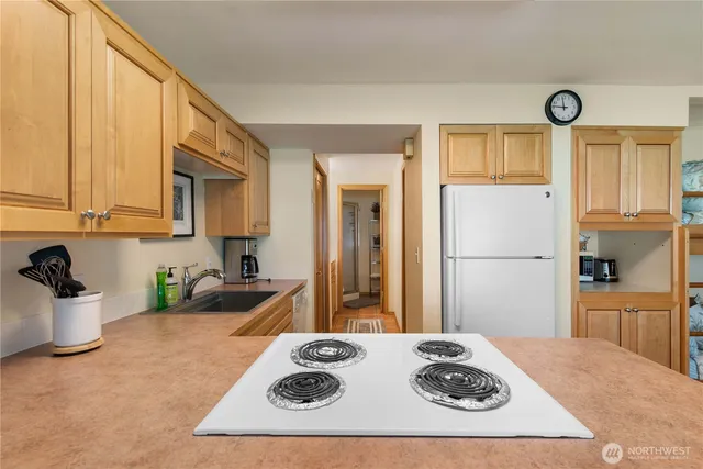 a kitchen with a refrigerator and a stove top oven