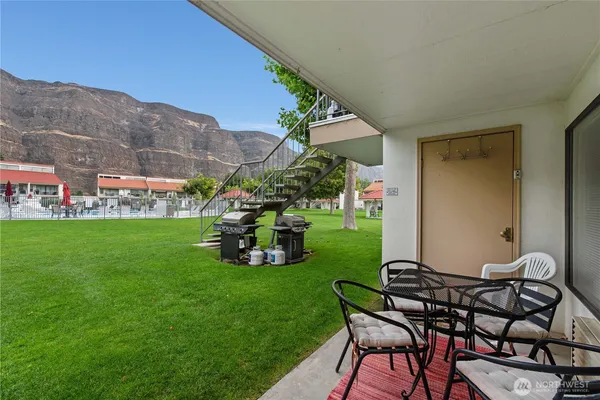 a view of a chair and table in backyard of the house