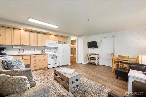 a open kitchen with stainless steel appliances granite countertop a stove top oven a sink dishwasher and a fireplace with wooden floor