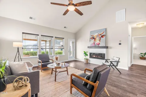 a living room with furniture a fireplace and a floor to ceiling window
