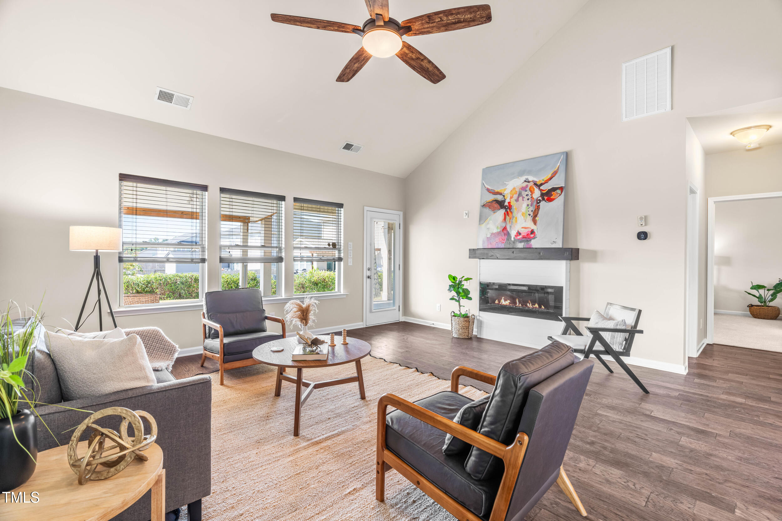 1304 Ivey Grove Court Fuquay-Varina, NC 27526 - Photo 17 of 44 a living room with furniture a fireplace and a floor to ceiling window