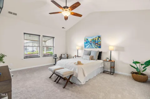 a spacious bedroom with a bed and a chandelier