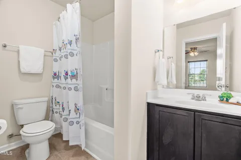 a bathroom with a sink a toilet and shower curtain