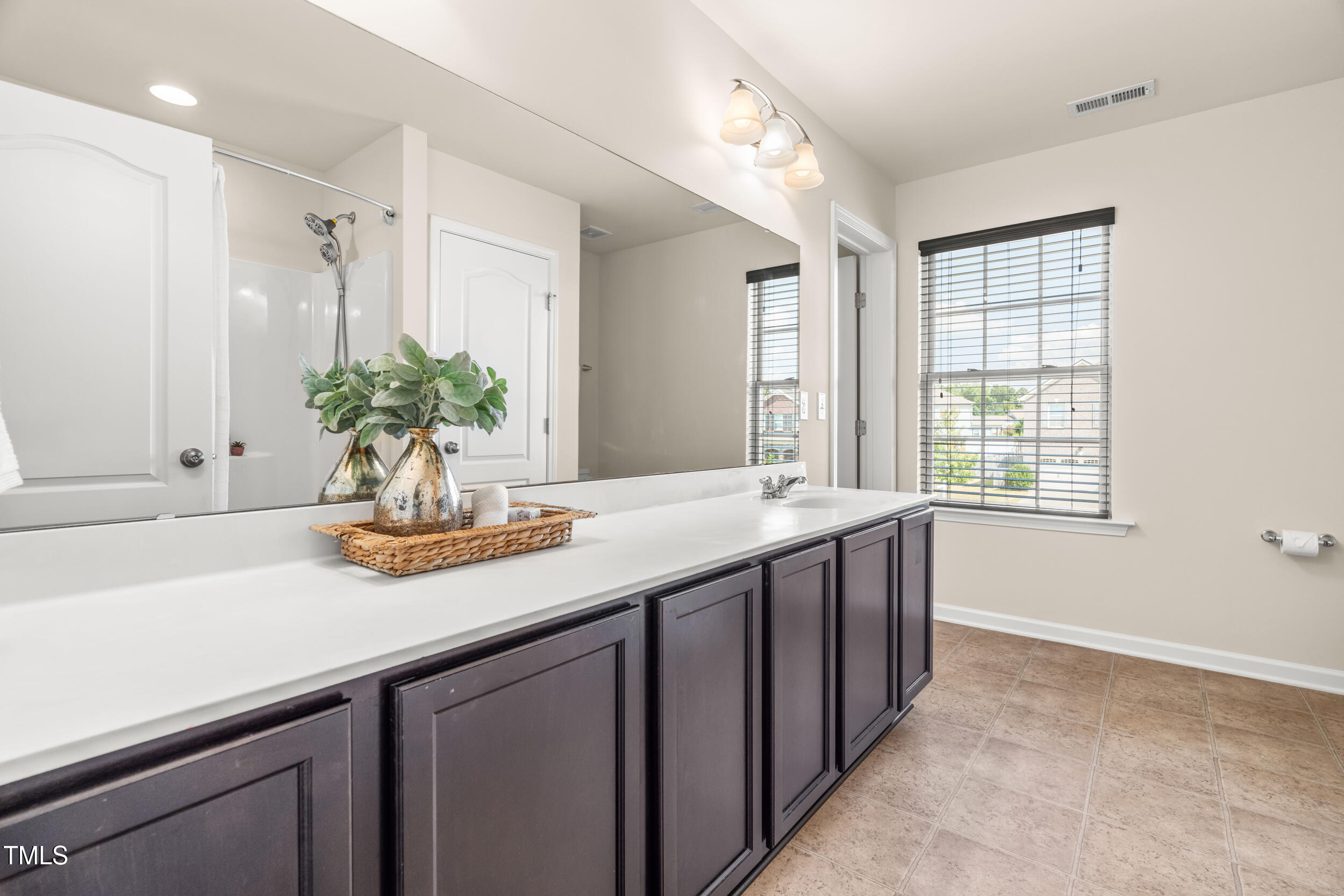 1304 Ivey Grove Court Fuquay-Varina, NC 27526 - Photo 30 of 44 a bathroom with a granite countertop sink a large mirror a and a window