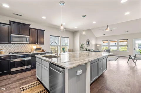 a kitchen with stainless steel appliances granite countertop a sink stove and cabinets