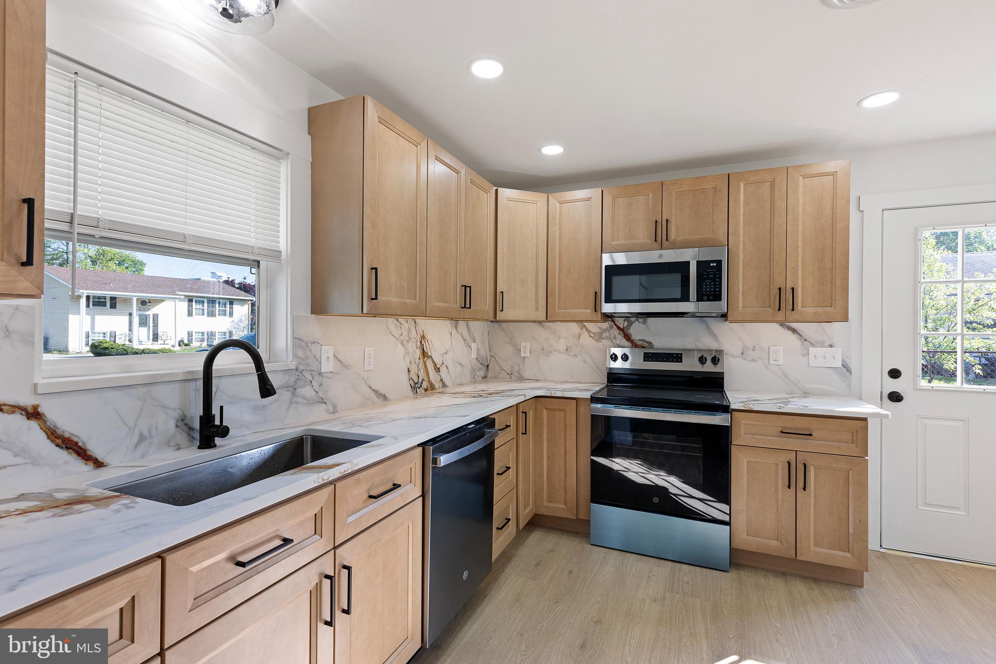 3 Queens Way Newark, DE 19713 - Photo 4 of 20 a kitchen with kitchen island granite countertop a sink stainless steel appliances and cabinets