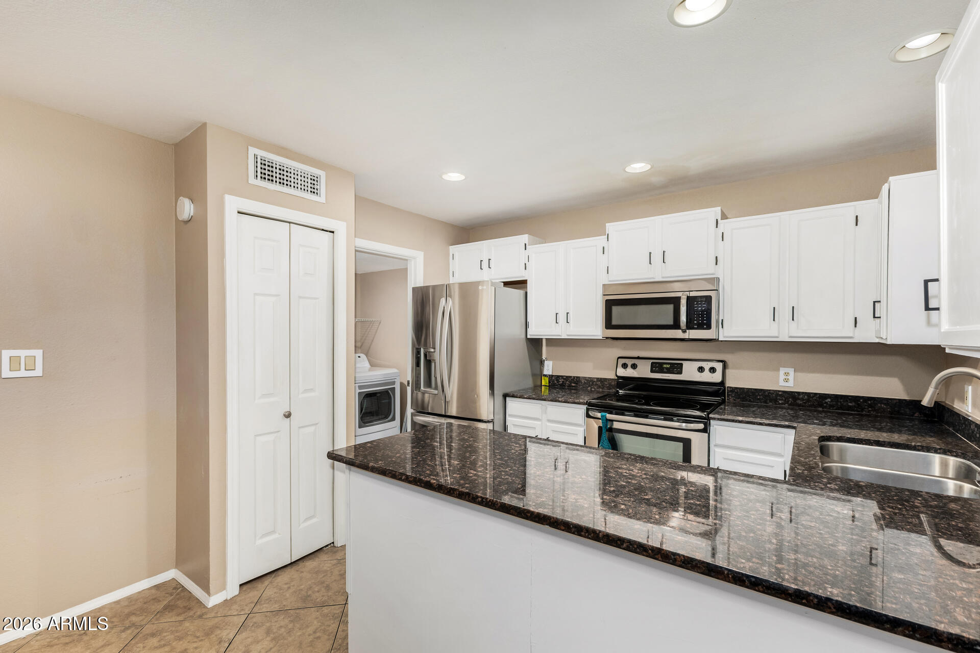 6262 East Brown Road, Unit 29 Mesa, AZ 85205 - Photo 17 of 59 a kitchen with stainless steel appliances granite countertop a stove a sink and a refrigerator