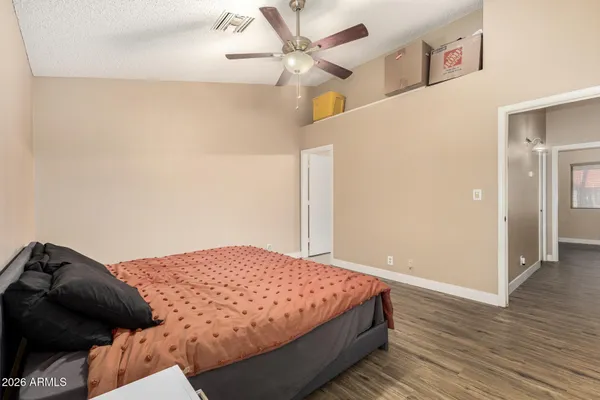 a bedroom with a bed and wooden floor