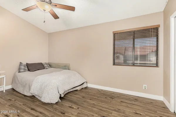 a bedroom with a bed and wooden floor