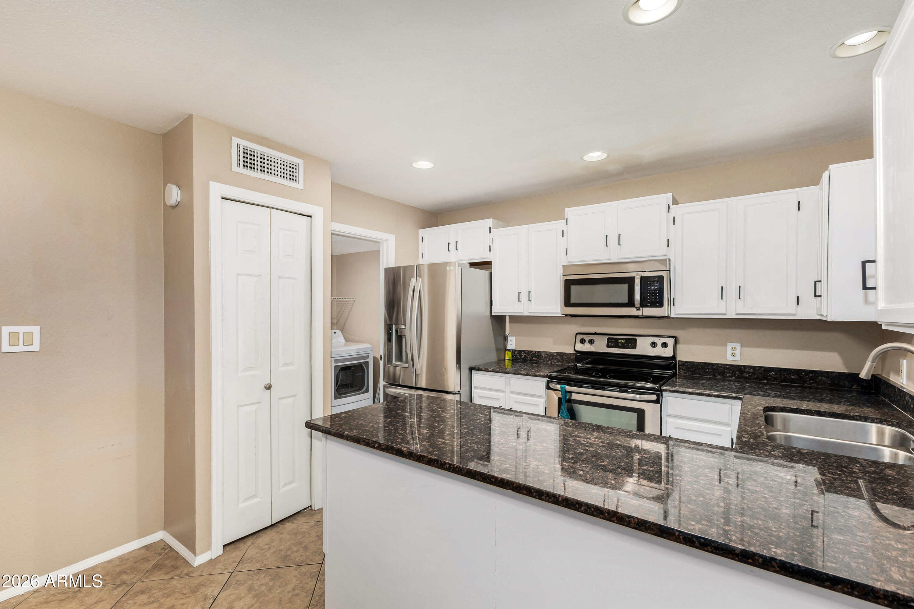 6262 East Brown Road, Unit 29 Mesa, AZ 85205 - Photo 20 of 59 a kitchen with stainless steel appliances granite countertop a stove a sink and a refrigerator