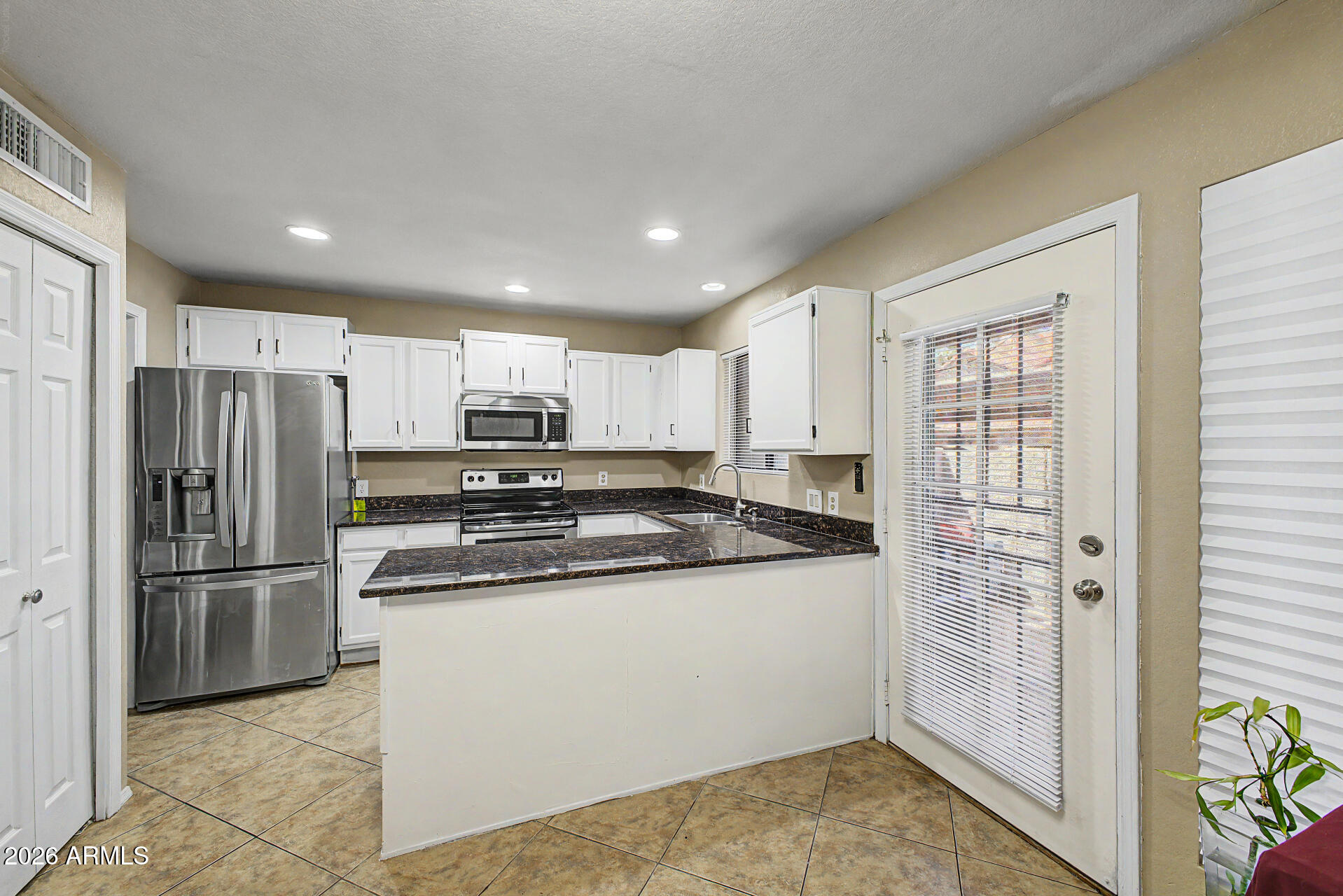 6262 East Brown Road, Unit 29 Mesa, AZ 85205 - Photo 3 of 59 a kitchen with stainless steel appliances granite countertop a refrigerator and a stove top oven