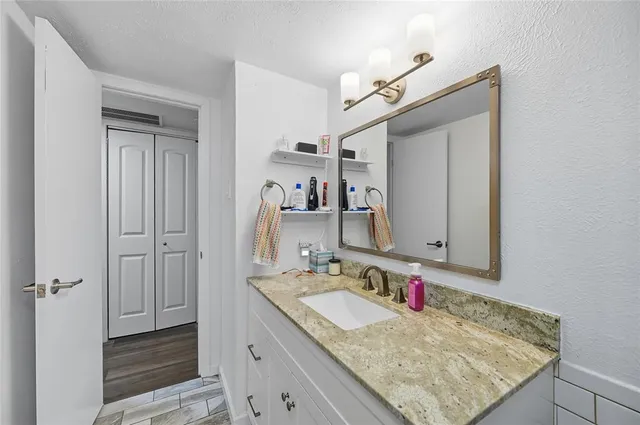a bathroom with a granite countertop sink and a mirror