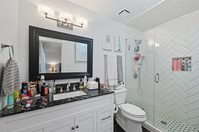 a bathroom with a sink vanity mirror and toilet