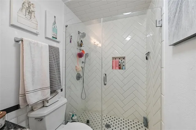 a bathroom with a shower toilet and sink
