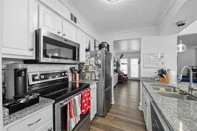 a kitchen with stainless steel appliances granite countertop a stove refrigerator and microwave