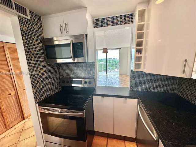a kitchen with stainless steel appliances wooden cabinets stove and a window