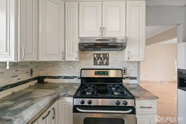 a kitchen with granite countertop a stove sink and cabinets