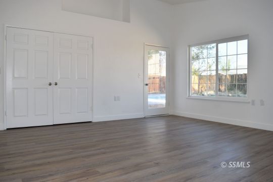1132 West Robert Avenue Ridgecrest, CA 93555 - Photo 27 of 38 a view of an empty room with wooden floor and a window