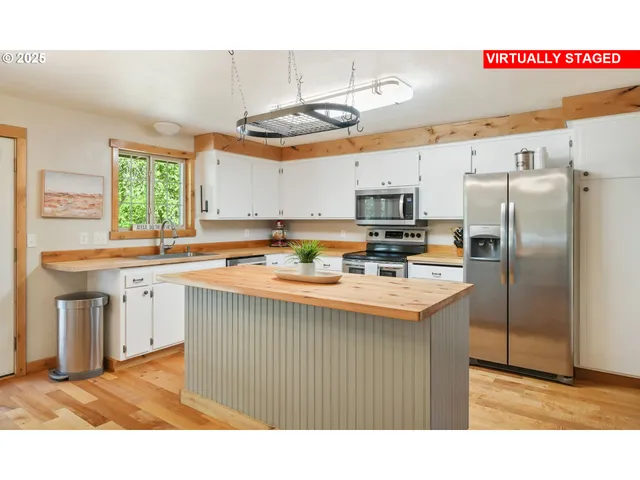 a kitchen with kitchen island granite countertop a sink stainless steel appliances and cabinets