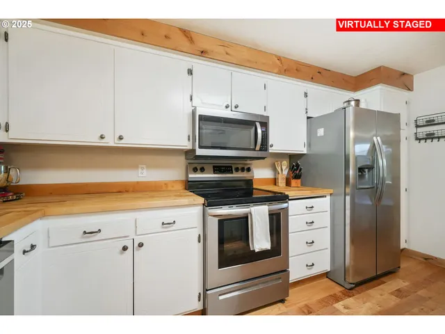 a kitchen with stainless steel appliances white cabinets and a refrigerator