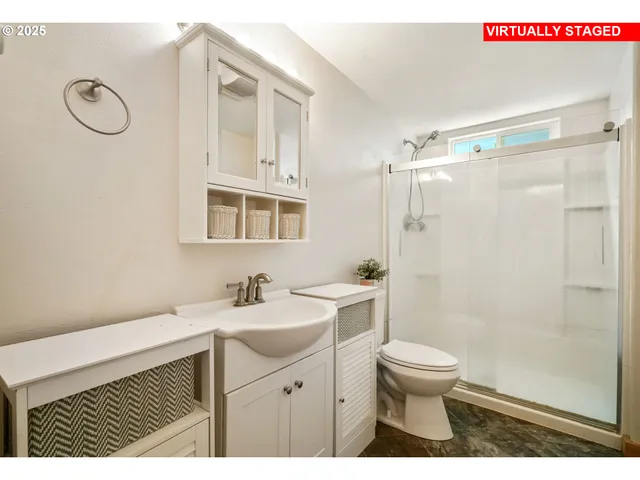 a bathroom with a sink a toilet and shower