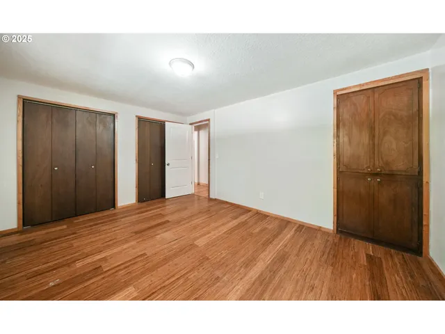 a open hall with wooden floor and closet area