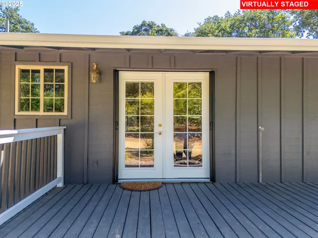 an empty room with wooden floor and a yard