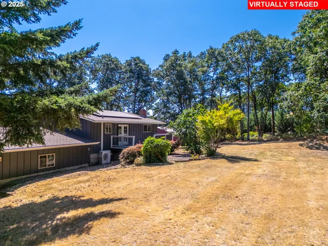 a front view of house with yard and trees in the background