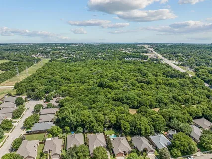 an aerial view of residential houses with outdoor space and trees