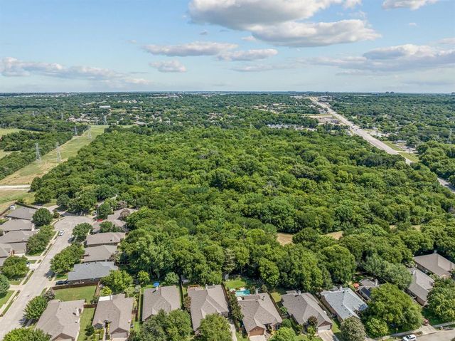 an aerial view of residential houses with outdoor space and trees