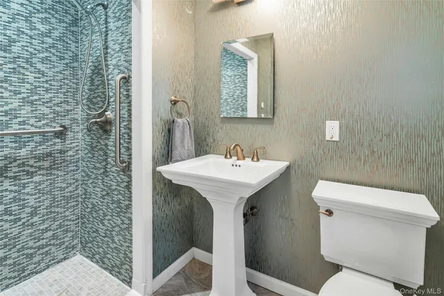 a bathroom with a sink a toilet and shower