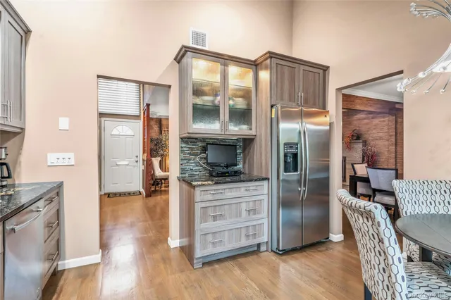 a kitchen with stainless steel appliances a refrigerator and wooden floor