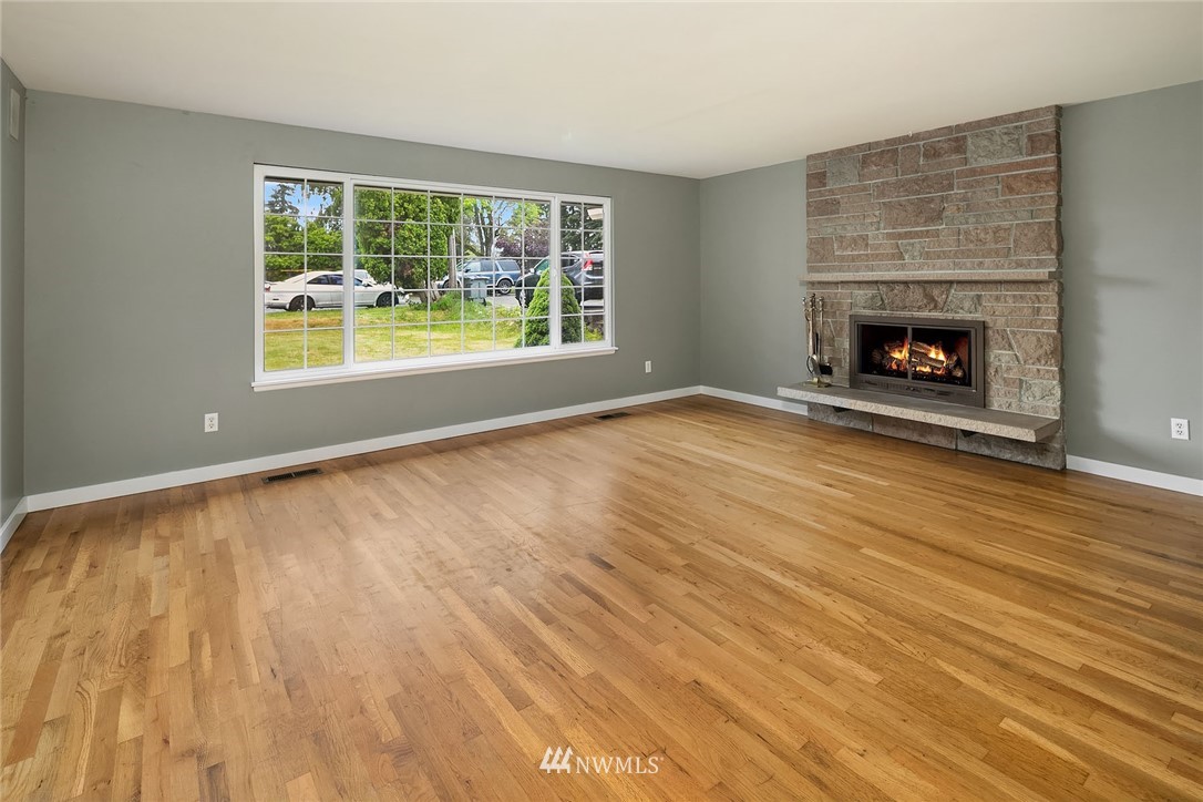 1110 Olympia Avenue Northeast Renton, WA 98056 - Photo 4 of 20 a view of an empty room with wooden floor and a window